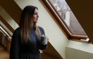 Rosa Rossi mit einer Tasse in der Hand