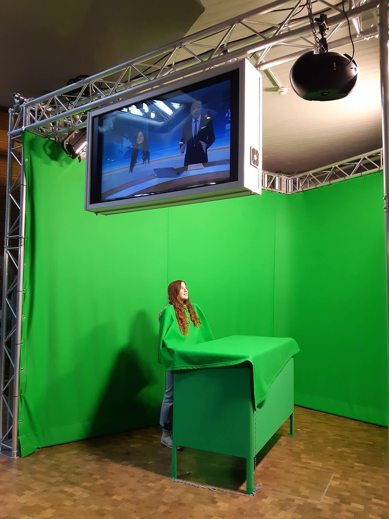 Eine Freiwillige in einem Greenscreen während der Besichtigung eines Fernsehstudios