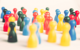 sehr viele Mensch-ärger-dich-nicht Menschen in rot, grün, gelb und blau gemischt