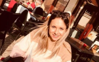 Jana Reineke sitzt in einem Café, auf dem Bild lächelt sie