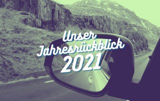 Rückspiegel eines Autos darüber die Aufschrift "Unser Jahresrückblick 2021"